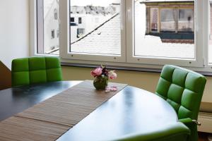 a table with a vase of flowers on top of it at Ferienwohnung Skyline Suite in Bayreuth +12 photos