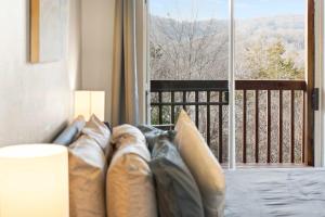 a couch with pillows sitting in front of a window at Silver Lake Hideaway - Chic 2 BDR Dog Friendly in Branson