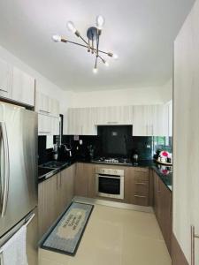 サンティアゴ・デ・ロス・カバリェロスにあるTranquilo y acogedorのキッチン(木製キャビネット、ステンレス製の冷蔵庫付)