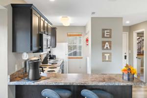 a kitchen with black cabinets and a counter top at Silver Lake Hideaway - Chic 2 BDR Dog Friendly in Branson +16 photos