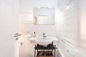 a white bathroom with a sink and a mirror at Eden Rentals Pure Abona in Poris de Abona +33 photos