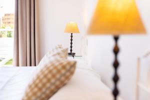 a bed with a lamp sitting next to a window at Eden Rentals Pure Abona in Poris de Abona