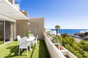 a balcony with a table and chairs and the ocean at Eden Rentals Pure Abona in Poris de Abona