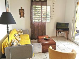 レ・トロワ・イレにあるT3 Hibiscusのリビングルーム(黄色のソファ、テレビ付)