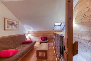 a living room with a brown couch and red pillows at Granges 31 - Duplex 6pers Pied in Villard-Reculas