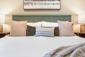 a bedroom with a white bed with pillows at Penthouse 7 on Taneycomo - Chic Waterfront Condo in Branson