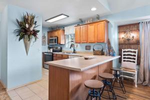 a kitchen with wooden cabinets and a kitchen island with stools at Par 7 Penthouse at StoneBridge Resort in Branson West