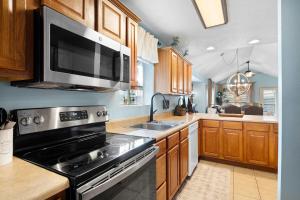 a kitchen with a stove and a microwave at Par 7 Penthouse at StoneBridge Resort in Branson West +14 photos