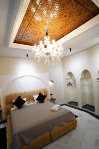 a bedroom with a large bed and a chandelier at Le 146 - Art of Living in Rabat