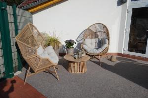 two wicker chairs and a table on a patio at Küstenloft-Leuchturm in Rostock
