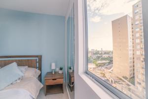 a bedroom with a bed and a large window at Apartaestudio Norte de Armenia in Armenia