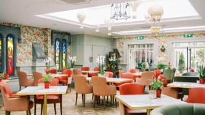 a dining room with tables and chairs and windows at Ballyseede Castle in Tralee