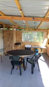 a ping pong table and two chairs in a pavilion at Camping Sainte-Jalle in Sainte-Jalle