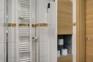 a bathroom with a shower with white tiles at Modern Apartments Neuburg 2 - New in Neuburg an der Donau +11 photos