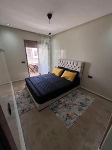 a bedroom with a bed with yellow pillows at Appartement à residence MALAGA BEACH in Mansouria