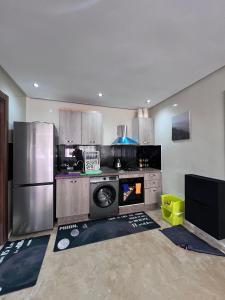 a kitchen with a stove and a refrigerator at Appartement à residence MALAGA BEACH in Mansouria