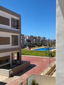 a view of a apartment building with a swimming pool at Appartement à residence MALAGA BEACH in Mansouria
