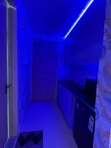 una habitación oscura con una luz azul en un dormitorio en elite stay one, en Greater Noida