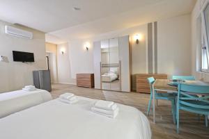 a hotel room with two beds and a table and chairs at City Loft in Piacenza