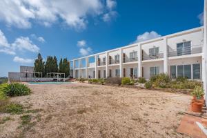 a large white building with a yard in front of it at Alto da Lua in Bordeira