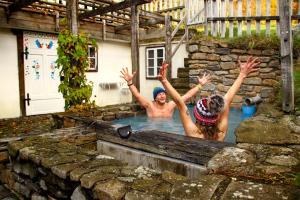 a man and a woman in a swimming pool at Cifrovaná drevenička in Detva