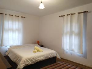 a bedroom with a bed with two yellow towels on it at Balkan Mountains Villa Spa in Elena