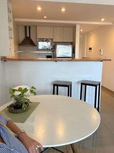 a white table in a kitchen with stools at Monoambiente con amenities Y MAS in Buenos Aires