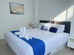 a bedroom with a large white bed with a flower on it at A&J Holiday Villa in Ban Na Bon +35 photos