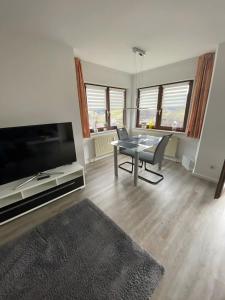 a living room with a table and a large tv at Ferienwohnung Bächle in Bad Peterstal +13 photos