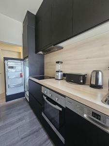 a kitchen with black cabinets and a counter top at Doble room with toilet in Ghent