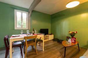 a dining room with green walls and a table and chairs at Cocon' Aire Charmant appartement au calme, proche centre, wifi in Aire-sur-lʼAdour