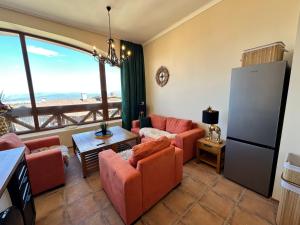 a living room with orange furniture and a large window at Murphys Lodge panorama apartment in Bansko