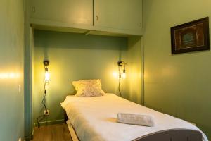 a small room with a bed with two lights on it at Cocon' Aire Charmant appartement au calme, proche centre, wifi in Aire-sur-lʼAdour