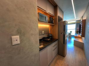 una cocina con fregadero y refrigerador en Art Studio Incredible roofop by VLV Stays, en Salvador