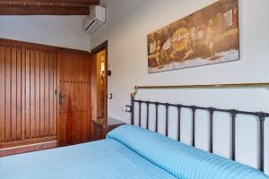 a bedroom with a bed with a blue bedspread at La Acacia in Martos +37 photos