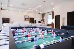 une table de billard avec des figurines dessus dans une pièce dans l'établissement Tiger House River Kwai, à Ban Tha Thong Mon