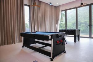 une chambre avec deux billards et un piano dans l'établissement Tiger House River Kwai, à Ban Tha Thong Mon