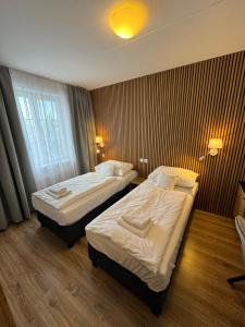 a hotel room with two beds and a window at Hotel ROSE Břeclav in Břeclav