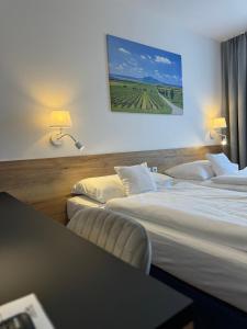 una habitación de hotel con tres camas y una mesa en Hotel ROSE Břeclav, en Břeclav