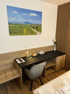 a desk in a room with a picture on the wall at Hotel ROSE Břeclav in Břeclav
