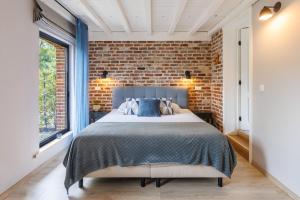 a bedroom with a brick wall and a bed at B&B Hof Ter Koningen in Aalst