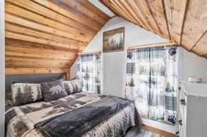 a bedroom with a bed and two windows at Copper Kettle Lodge in Cook Forest in Sigel
