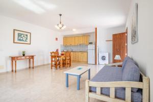 a living room and kitchen with a couch and a table at Apartamentos Karin 2ºe in Cala d´Or