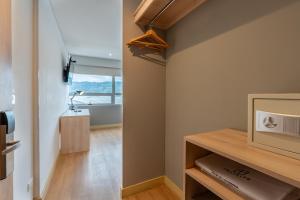 a small room with a tv and a bathroom at Pop Art Hotel Tocancipá y Centro de Convenciones in Tocancipá +15 photos