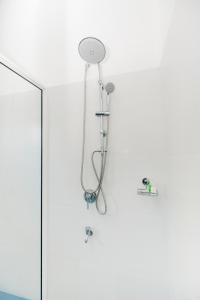 a shower with a shower head hanging on a wall at Teya Beach Hotel in Ahangama