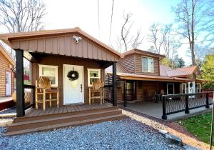 a small house with a wooden porch and a deck at Copper Kettle Lodge in Cook Forest in Sigel
