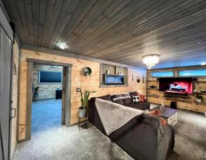 a living room with a couch and a tv at Copper Kettle Lodge in Cook Forest in Sigel