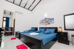 a bedroom with a blue bed with a flat screen tv at Teya Beach Hotel in Ahangama +142 photos