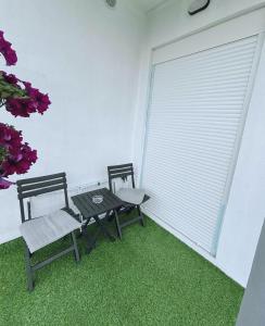 two chairs and a table in a room with a window at ViS APARTMAN in Trebinje