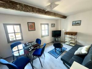 salon z kanapą, stołem i krzesłami w obiekcie studio cœur de ville 25 m2 avec vue cathédrale w mieście Narbona